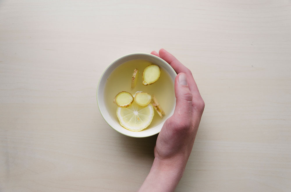 hand with mug of honey ginger tea